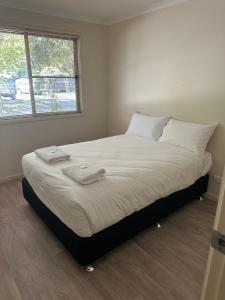 1 dormitorio con 1 cama grande y 2 toallas. en Mudgee Riverside Park en Mudgee