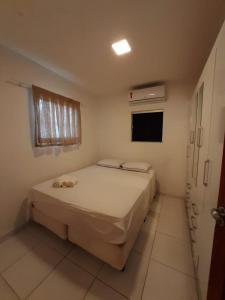 a small bedroom with a bed and a window at Casa Alto da Falésia in Baía Formosa