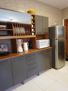 a kitchen with a refrigerator and a microwave at Casa Alto da Falésia in Baía Formosa