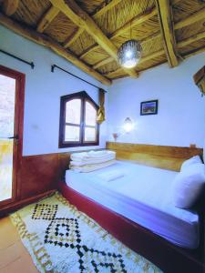 a bedroom with a large bed in a room at Riad pizzeria Marhaba in Akhendachou nʼAït Ouffi