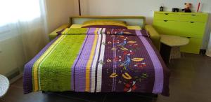 a bedroom with a bed with a colorful blanket at Elfe-Apartments Two-room Apartment with Garden, 2-4 guests in Emmetten