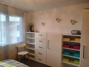 a bedroom with a white cabinet and a chair at Elfe-Apartments Two-room Apartment with Garden, 2-4 guests in Emmetten