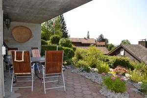 eine Terrasse mit Stühlen und einem Tisch im Garten in der Unterkunft Elfe-Apartments Two-room Apartment with Garden, 2-4 guests in Emmetten