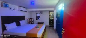 a small bedroom with a bed and a blue door at SRIKRUTI SEA VIEW in Puri