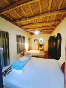 a bedroom with a large white bed in a room at Riad pizzeria Marhaba in Akhendachou nʼAït Ouffi