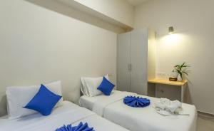 2 Betten in einem Zimmer mit blauen Kissen in der Unterkunft Family Style 3-Bedroom Suite by Baahu Villa in Siem Reap