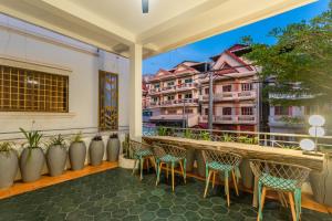 einen Balkon mit Stühlen und Blick auf ein Gebäude in der Unterkunft Family Style 3-Bedroom Suite by Baahu Villa in Siem Reap