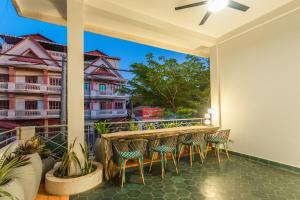 eine Terrasse mit einem Tisch und Stühlen auf dem Balkon in der Unterkunft Family Style 3-Bedroom Suite by Baahu Villa in Siem Reap