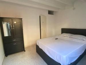 - une chambre avec un grand lit et une commode dans l'établissement Apartaestudio Socorro Calle 16a # 7-37, à Socorro