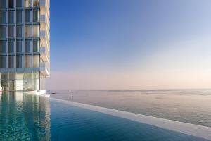 a swimming pool next to a building next to the ocean at SEAMARQ HOTEL in Gangneung