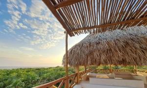 a straw hut with a view of the ocean at Casa Baloo in El Cuyo