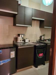 a kitchen with a stove and a dishwasher at Apartamentos La Floresta in Cochabamba