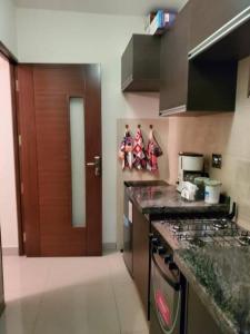 a kitchen with a counter and a stove top oven at Apartamentos La Floresta in Cochabamba