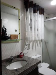a bathroom with a sink and a toilet and a mirror at Apartamentos La Floresta in Cochabamba