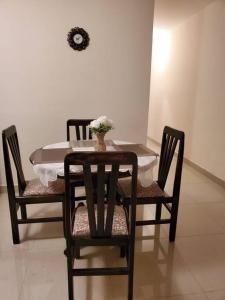 a table and chairs with a vase of flowers on it at Apartamentos La Floresta in Cochabamba