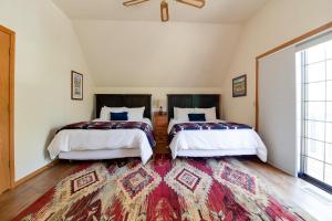 two beds in a room with a large rug at Lariat House in Sisters +57 photos