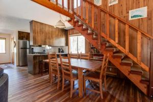 cocina y comedor con mesa de madera y escaleras en Peters Cabin, en Sisters