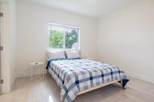 una camera da letto bianca con un letto e una finestra di Cozy 3 Bed 2 Bath Apt W Free Parking Near Beach! a Hallandale Beach