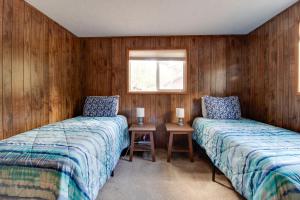 Dos camas en una habitación con paredes de madera. en Peters Cabin, en Sisters 38 fotos más