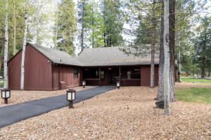 un granero rojo con un árbol delante de él en Peters Cabin, en Sisters