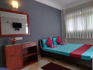 a bedroom with a blue bed with red and blue pillows at Mountain View in Kandy