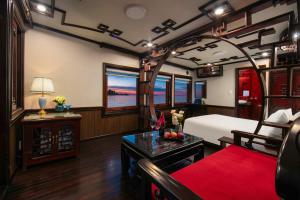a train room with a bed and a table at Majestic Legend Cruise in Ha Long