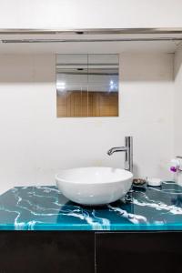 lavabo en el baño con un tazón blanco en la encimera en El Nido de la Cigüeña, en Alcalá de Henares