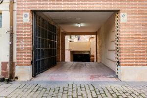una puerta de garaje abierta de un edificio de ladrillo en El Nido de la Cigüeña, en Alcalá de Henares