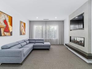 a living room with a blue couch and a fireplace at 45 On Fairway in Yarrawonga