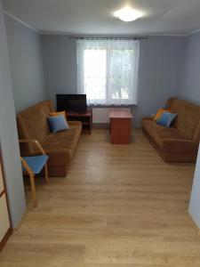 a living room with two couches and a television at Dom na Cichej in Krynica Morska