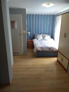 a bedroom with a bed and a blue wall at Dom na Cichej in Krynica Morska