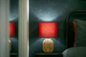 una lámpara roja sentada en una mesa junto a una cama en Strawberry Bank Apartment ✪ Grampian Lettings Ltd en Aberdeen