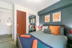 a bedroom with a large bed with orange pillows at Strawberry Bank Apartment ✪ Grampian Lettings Ltd in Aberdeen