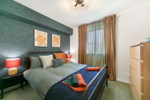 a bedroom with a large bed with orange pillows at Strawberry Bank Apartment ✪ Grampian Lettings Ltd in Aberdeen