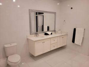 Baño blanco con lavabo y espejo en D'Rhatid Mansion, en Saint Mary