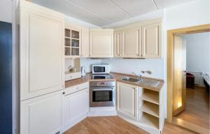 a kitchen with white cabinets and a sink at Pet Friendly Apartment In Kvam With Wi-fi in Kvam