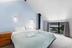 a bedroom with a large bed with two towels on it at The Twins in Queenstown