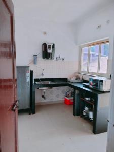 a kitchen with a desk with a microwave on it at RONNE'S Pamela 1BHK Apartment in Anjuna in Assagao
