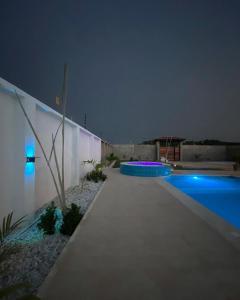 una piscina por la noche junto a una valla en HERMOSA CASA PLAYERA CON MESA DE BILLAR, en Juan de Acosta