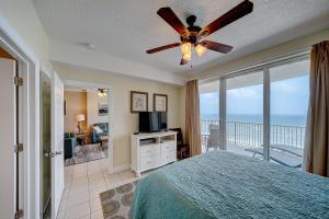 a bedroom with a bed and a ceiling fan at Ocean Villa 1104 in Panama City Beach