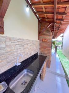 a kitchen with a sink and a brick wall at Chalé Gravatá - Privê Jardim de Marie in Gravatá