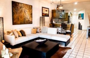 a living room with a white couch and a table at Terrasol Elite Premium Vacation Rentals in Cabo San Lucas