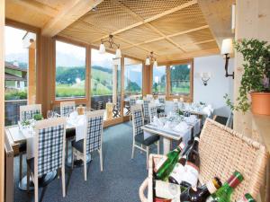 un comedor con mesas, sillas y ventanas en Hotel Falknerhof en Niederthai