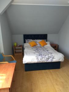 1 dormitorio con 1 cama con 2 almohadas de color naranja en Dom na Cichej, en Krynica Morska