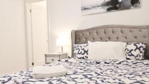 Schlafzimmer mit einem Bett mit einer blauen und weißen Bettdecke in der Unterkunft New Luxury Suite 6Mins To Falls, Free Parking in Niagara Falls