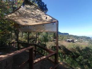 a wooden structure with a canopy in a field at Cabaña El Fresno 