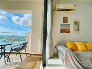 1 dormitorio con cama, mesa y balcón en Country Garden Danga Bay by Lions Bay en Johor Bahru