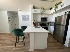 a kitchen with a white counter and a refrigerator at Great Apt Close Disney Spring in Orlando