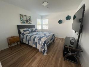 a bedroom with a bed and a flat screen tv at Great Apt Close Disney Spring in Orlando