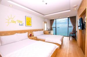 Cette chambre comprend deux lits et une télévision. dans l'établissement Nắng Vàng Nha Trang Hotel, à Nha Trang